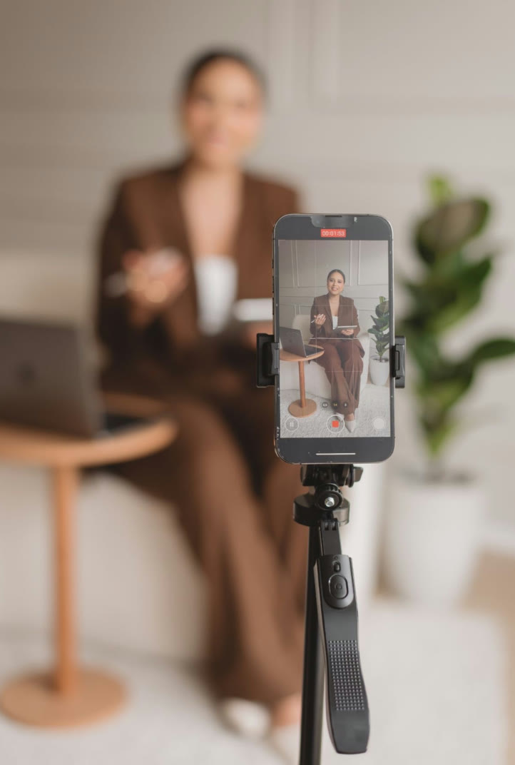 Celular no tripé gravando um vídeo de uma profissional