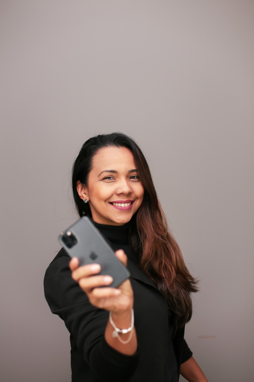 Keully Anne Reis sorrindo e segurando um celular
